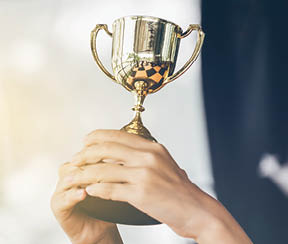 Teenage girls' hands are holding trophies, congratulations on success.Conception of victory in the competition.